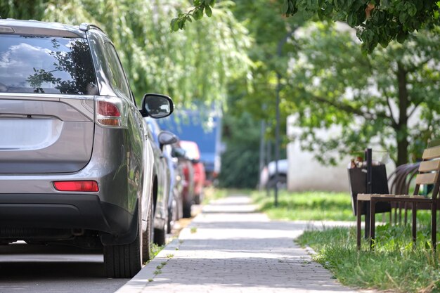 Cars parked in line on city street side Urban traffic concept