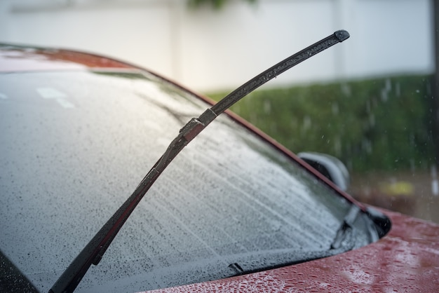 雨季に雨の中で駐車し、フロントガラスからフロントガラスを取り除くワイパーシステムを備えた車