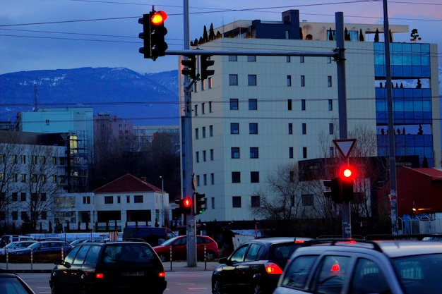 Cars parked on road in city against cloudy sky