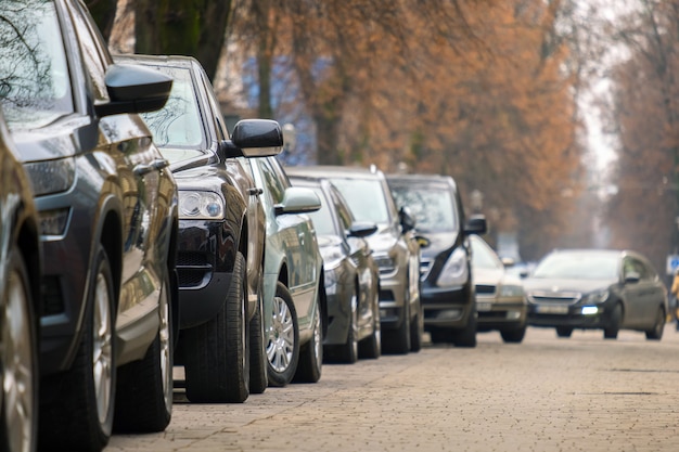 Машины припаркованы в ряд на обочине городской улицы.