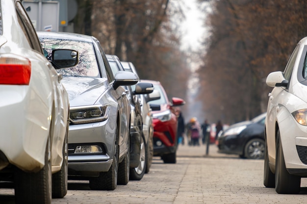 Машины припаркованы в ряд на обочине городской улицы.