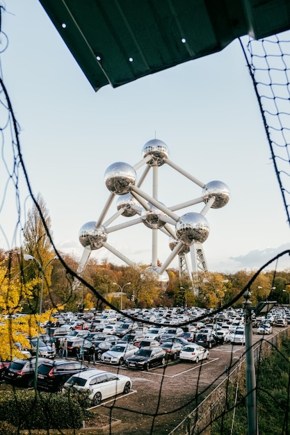 Cars parked on street against atomium in city