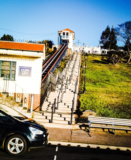 Cars on railroad track in city against clear sky