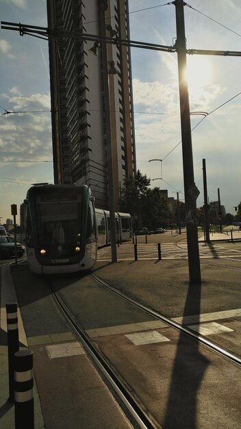 Foto auto sui binari della ferrovia in città contro il cielo