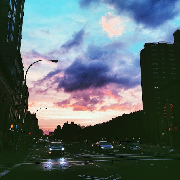 Cars on road against cloudy sky