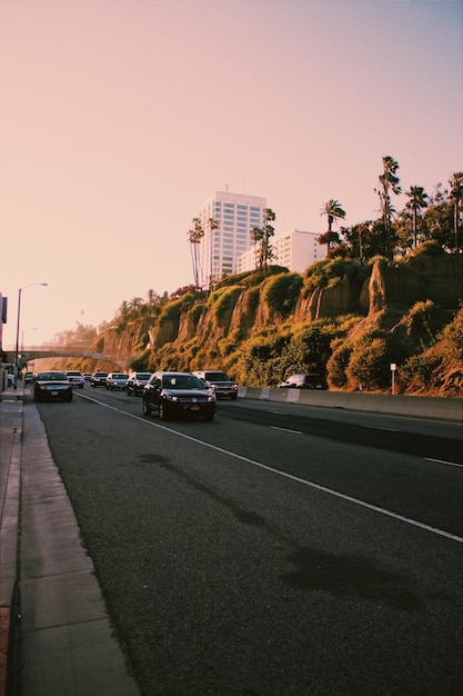 Photo cars on road against sky at sunset