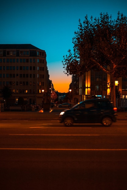 Foto auto per strada in città al crepuscolo