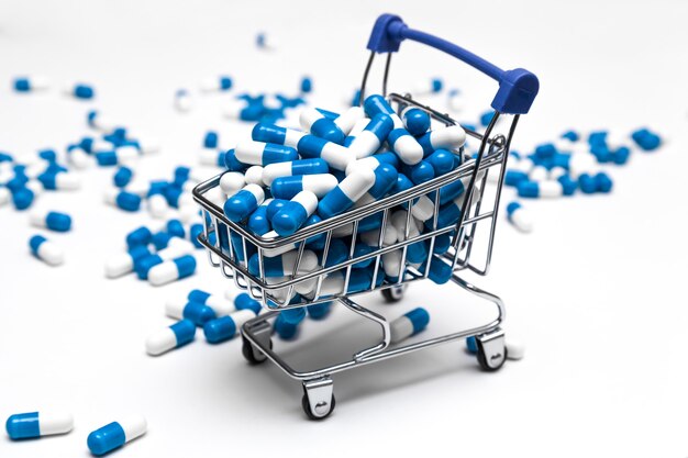 cart full of drugs online pharmacy drug shopping concept white and blue capsules