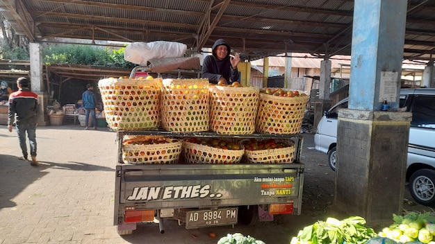 a cart full of produce including a woman and a car