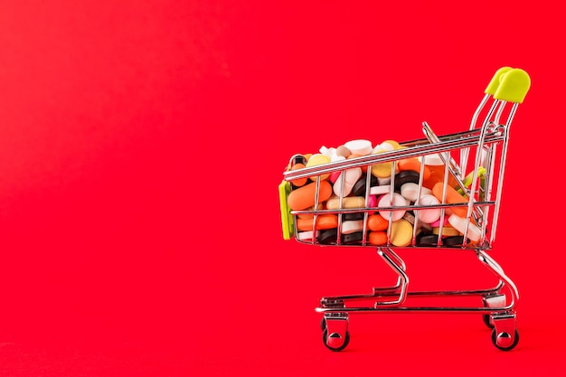 Cart of pills Red background Concept a complete set of medicines in the store Copy space for text