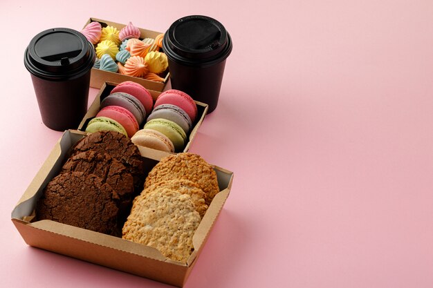 Carton box with oat cookies on pink table