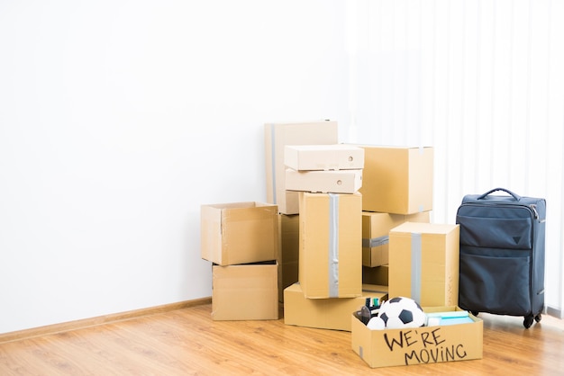 The carton boxes and suitcase on the parquet floor