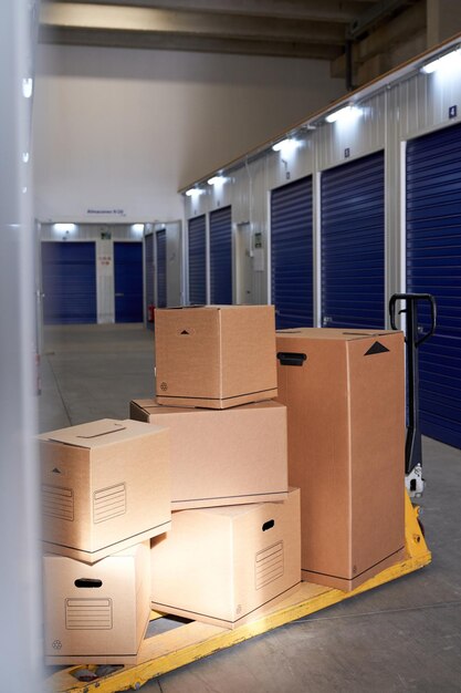 Carton containers on pallet jack in storehouse with roller
shutter