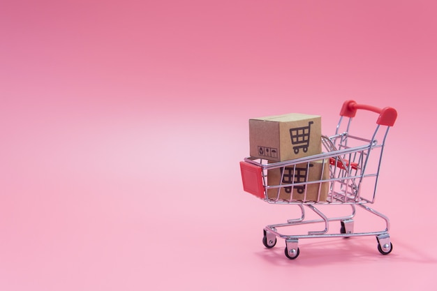 Cartons or Paper boxes in blue shopping cart on pink