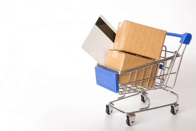 Cartons or Paper boxes and credit card in blue shopping cart on white background. 