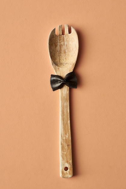 Cartoon man with a mustache from farfalle pasta and wooden spoon