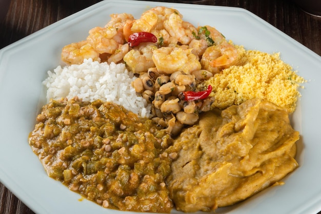 Caruru Traditional AfroBrazilian dish made with okra and dried shrimp accompanied by vatapa beans rice shrimp and farofa