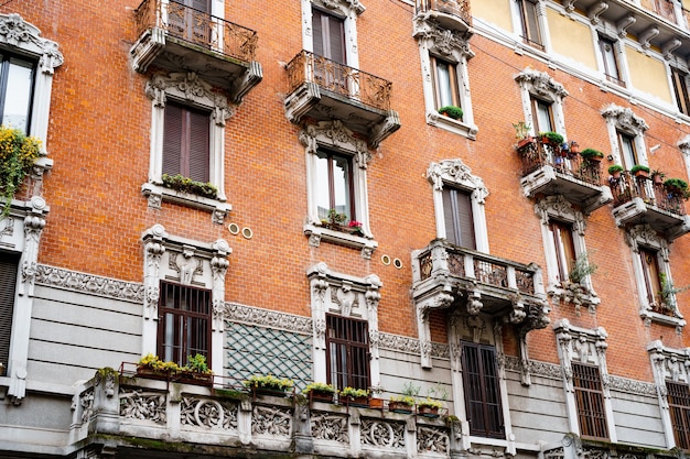 Balconi intagliati e cornici in pietra di stucco sopra le finestre della vecchia casa milano italia