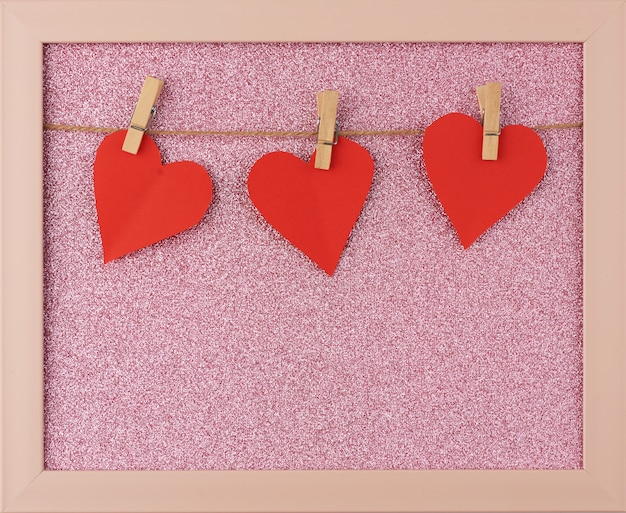 Carved red paper hearts hanging on a brown rope