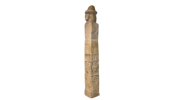 Photo a carved wooden pole with a hat on it