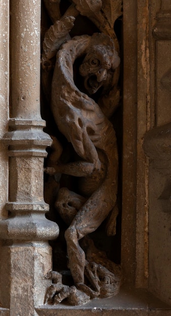 A carving of a dragon is on the wall of a church.