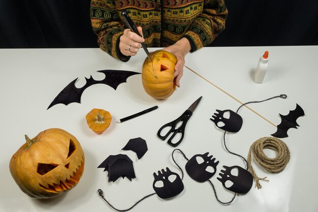 Foto carving een jack'o'lantern aan een tafel van bovenaanzicht