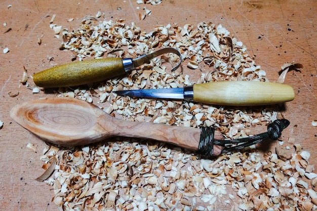 Carving knifes and a wooden spoon with wooden chips