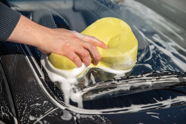 비누와 노란색 스폰지로 Carwash 개념 남자 세척 차