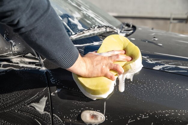 비누와 노란색 스폰지로 Carwash 개념 남자 세척 차