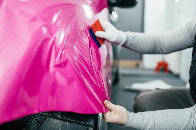 Carwrapping specialist die vinylfolie of folie op auto zet. selectieve aandacht.