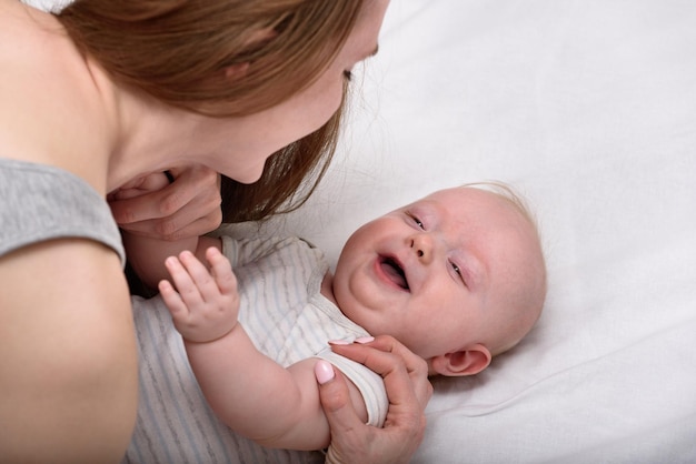 彼女の生まれたばかりの赤ちゃんの愛情のあるお母さんを運ぶ幸せな母性の概念の笑顔