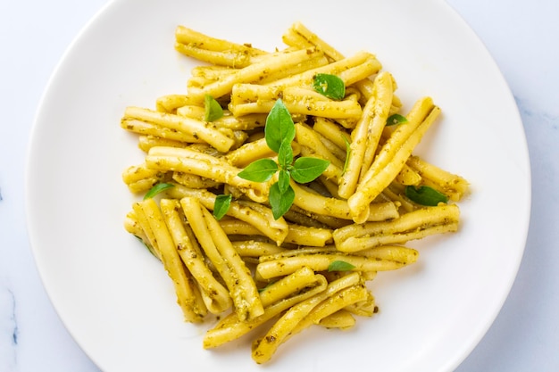 Casarece pasta met koriander pestosaus op een grijze achtergrond, bovenaanzicht. Heerlijke vegetarische lunch.