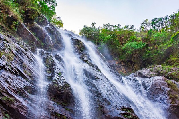 Фото Каскад чистой воды, протекающий между скалами и лесом в минас-жерайсе, бразилия