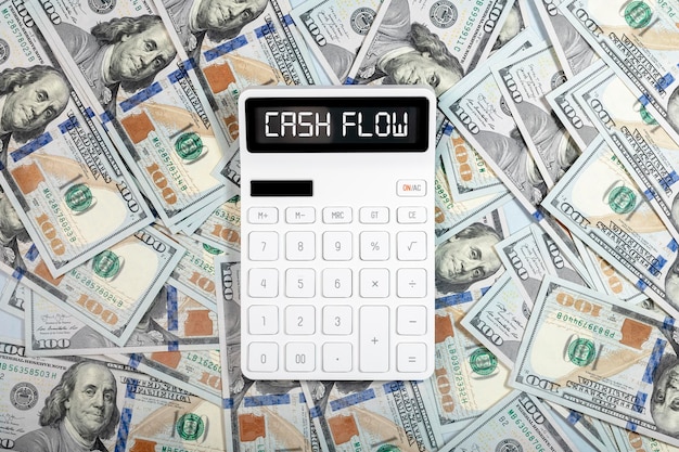 Cash flow concept cashflow word on calculator and dollars heap