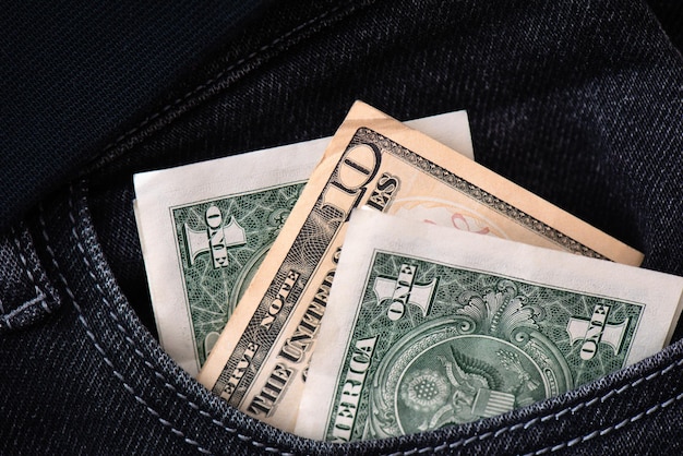 黒のジーンズのポケットに米ドルの現金紙幣紙幣の保管と交換の節約ビジネスの背景1ドルと10ドルのアメリカのお金