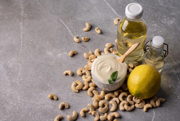 Foto crema di formaggio di anacardi in una ciotola bianca e ingredienti da cucina