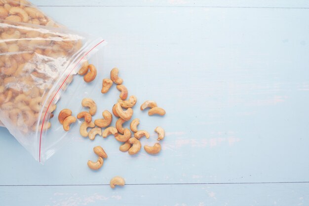 Cashew nut spilling from a plastic bag on table