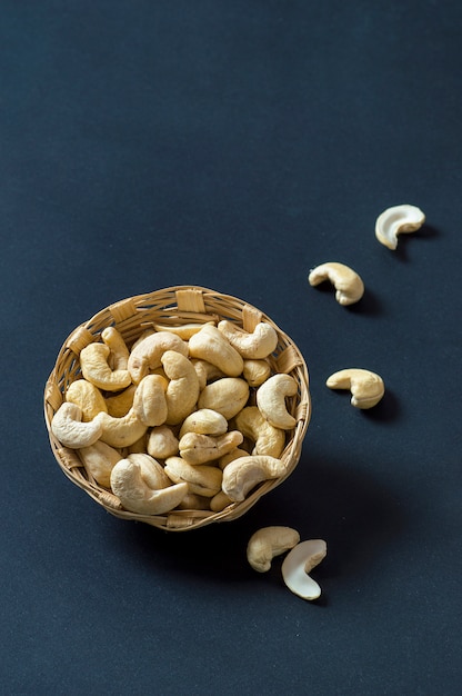 Photo cashew nuts in basket on black surface