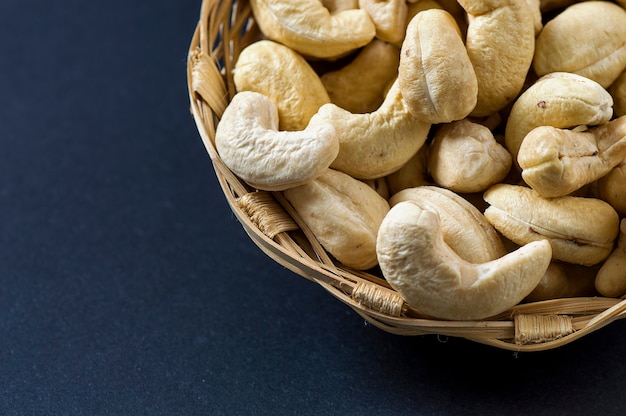 Cashew nuts in basket on black