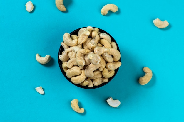 Орехи кешью в миску на синем фоне