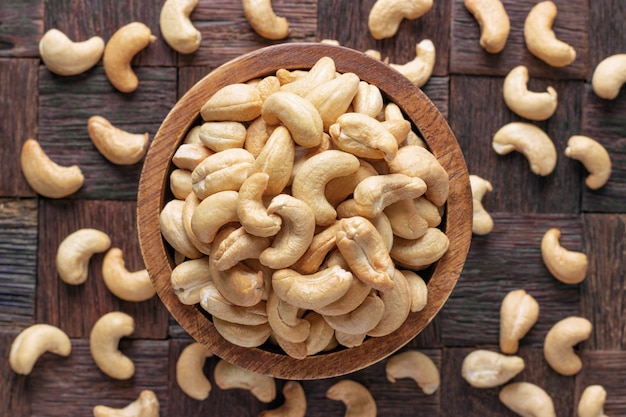 Gli anacardi si sono sbucciati arrostiti in ciotola di legno, vista superiore.