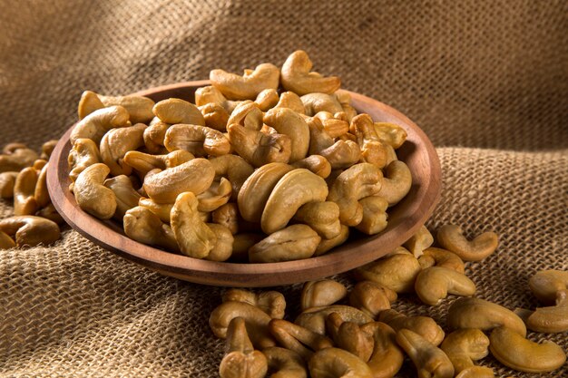 Cashew nuts in wood bowl on wood background