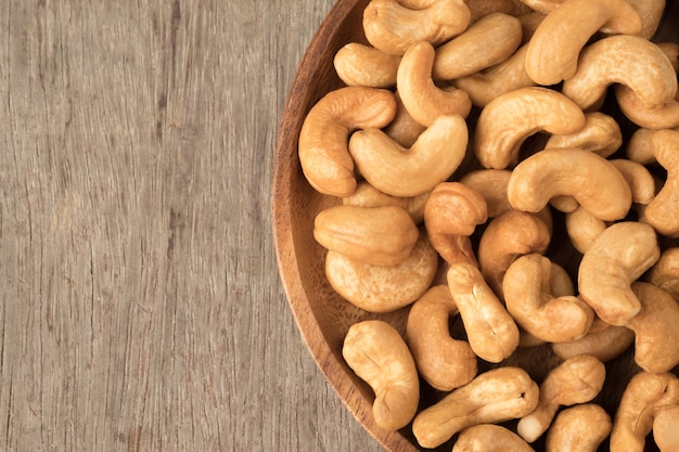 Cashew nuts in wooden bowl  on woden table.