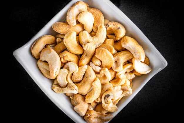 Cashewnoten in aardewerkpot op zwarte achtergrond