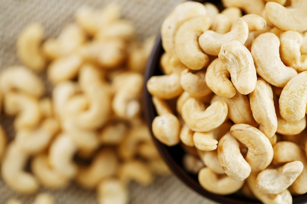 Cashewnoten in een houten kom op een achtergrond van de jutedoek