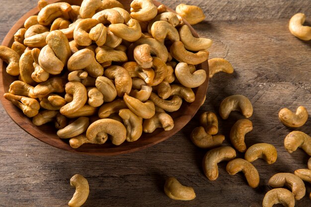 Cashewnoten in houten kom op houten achtergrond