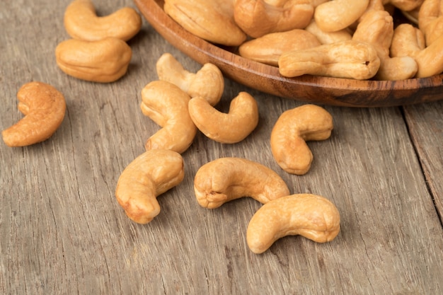 Cashewnoten in houten kom woden tafel.