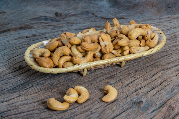 Cashewnoten in mand op Houten achtergrond wordt geïsoleerd die