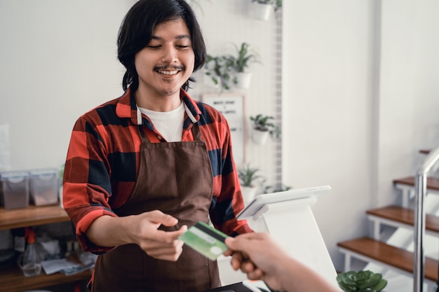 Cashier at the cafe accepts credit card payments