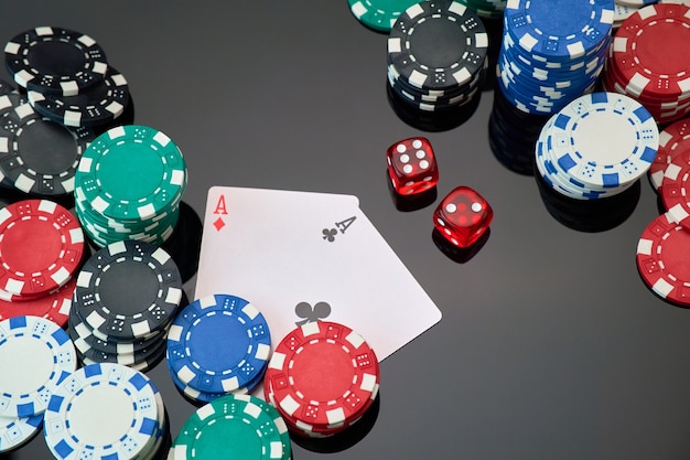 Casino chips playing cards and dices on dark reflective background